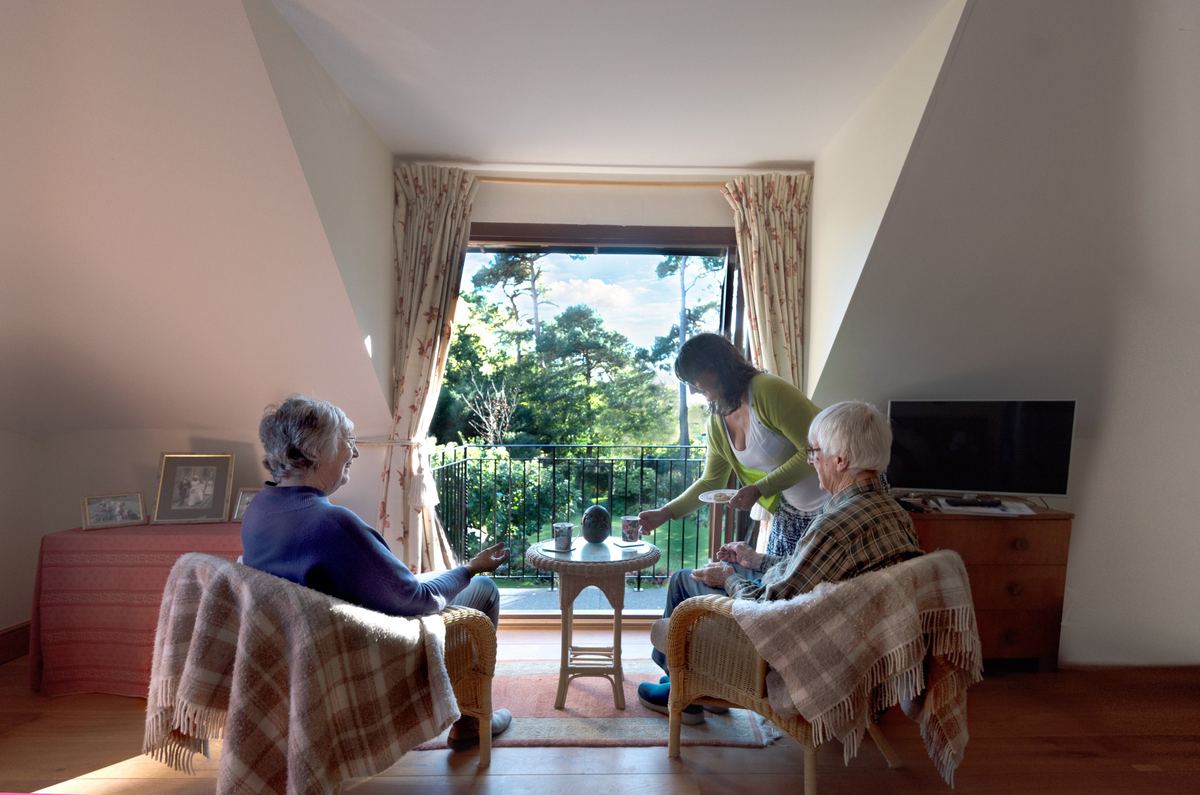 Care companion bringing tea to a couple at home