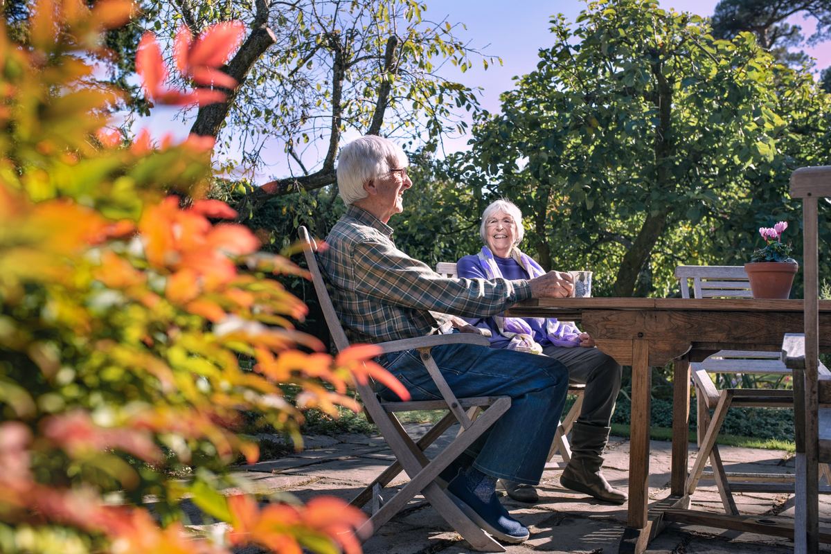 Couple enjoying a cup of tea together in their garden