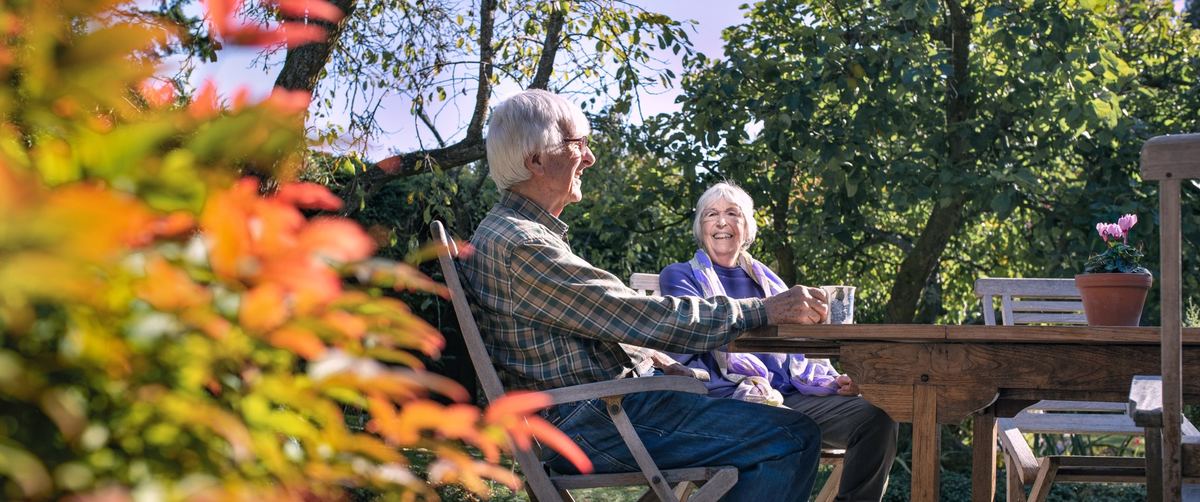 Couple enjoying a cup of tea together in their garden