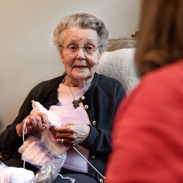 Elderly lady knitting at home